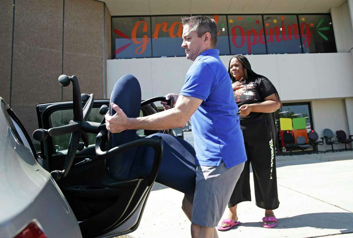 Erik Darmstetter, owner of Office Furniture Liquidations, loads an office chair for customer Mena Reeves on March 25, 2020.