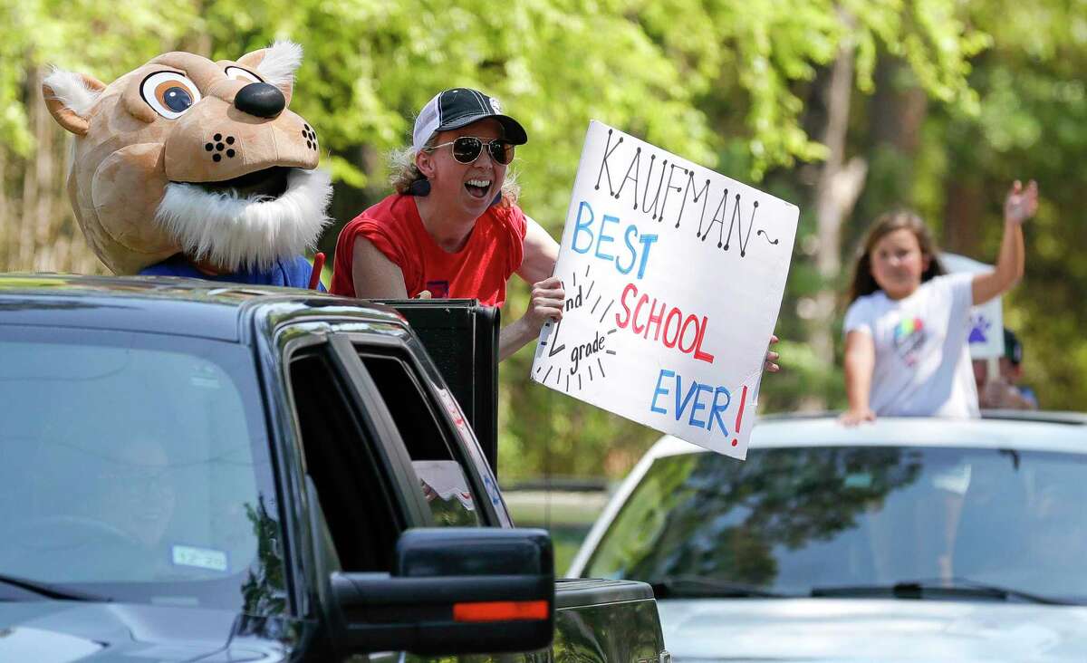 Second grade teacher Stephanie Shaw cheers as teachers with Kaufman Elementary School take part in a parade through nearby neighborhoods, Wednesday, March 25, 2020, in Spring.