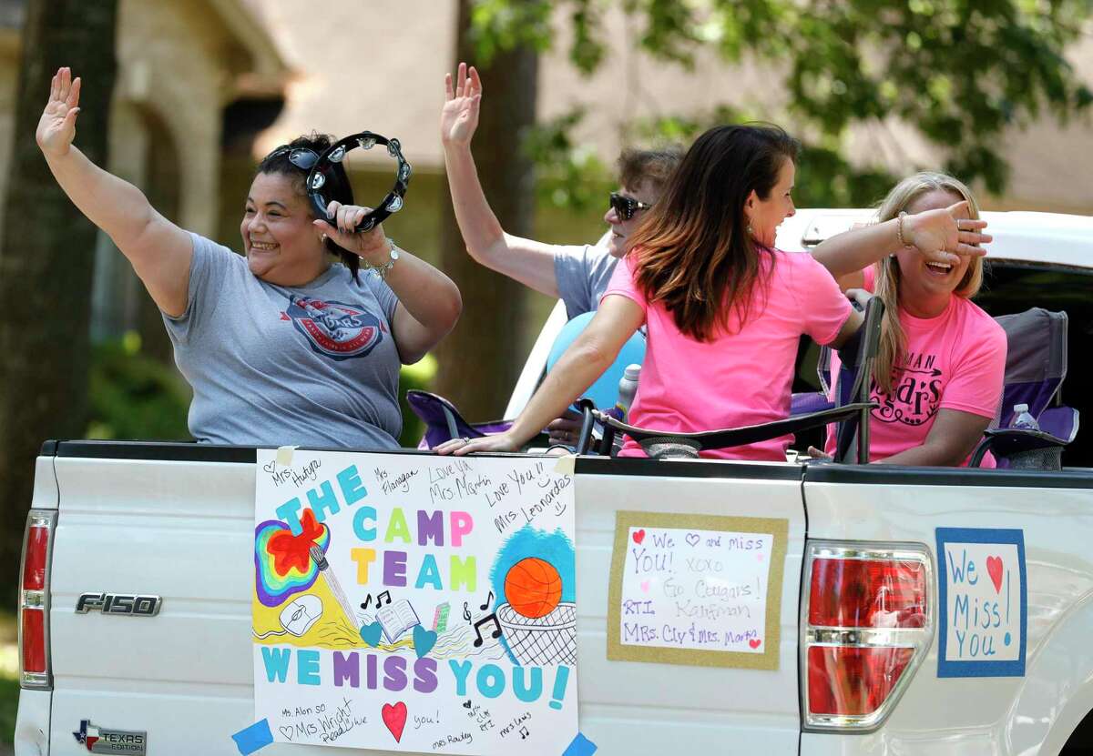 Teachers with Kaufman Elementary School take part in a parade through nearby neighborhoods, Wednesday, March 25, 2020, in Spring.