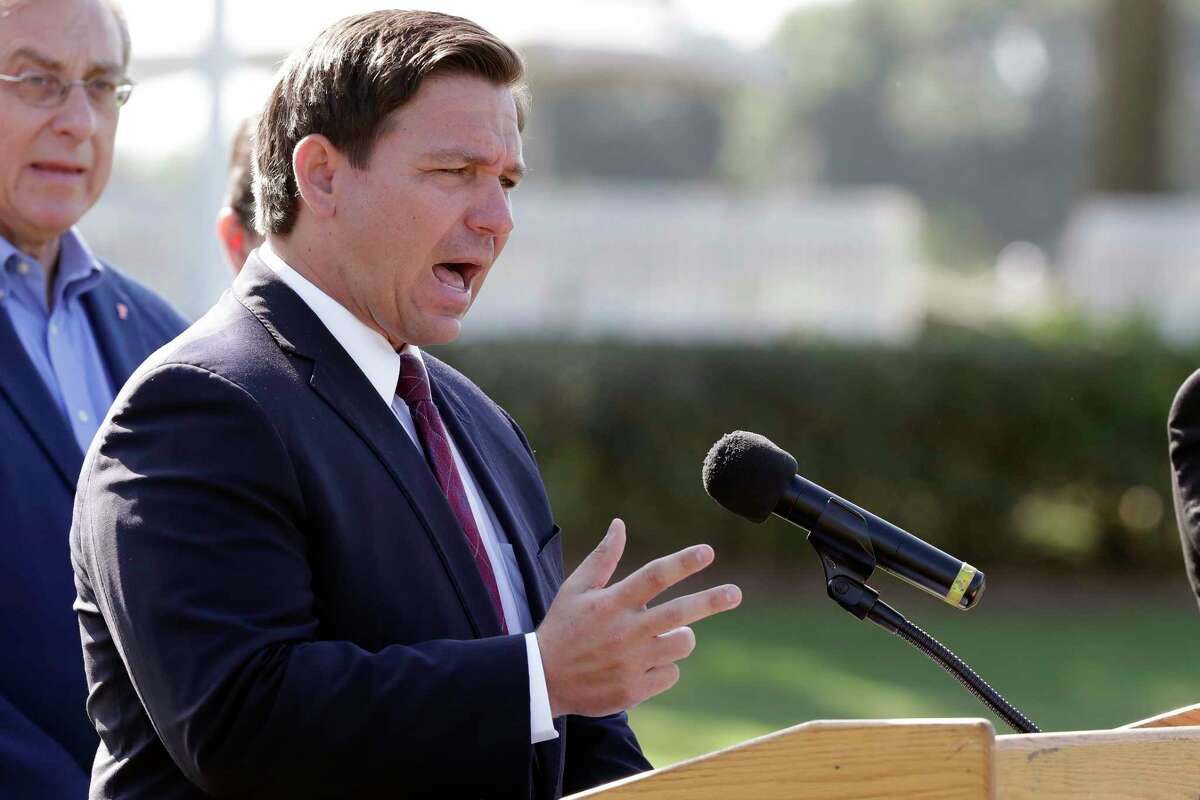 FILE- In this March 23, 2020 file photo, Florida Gov. Ron DeSantis delivers remarks during a press conference at a coronavirus mobile testing site in The Villages, Fla. The Villages, a retirement community, is one of the largest concentration of seniors in the U.S. Republican Gov. Ron DeSantis has been walking a tightrope for weeks during the coronavirus crisis, trying to protect both Floridians vulnerable to the virus and the cratering economy in a state of 21 million people.(AP Photo/John Raoux, File)