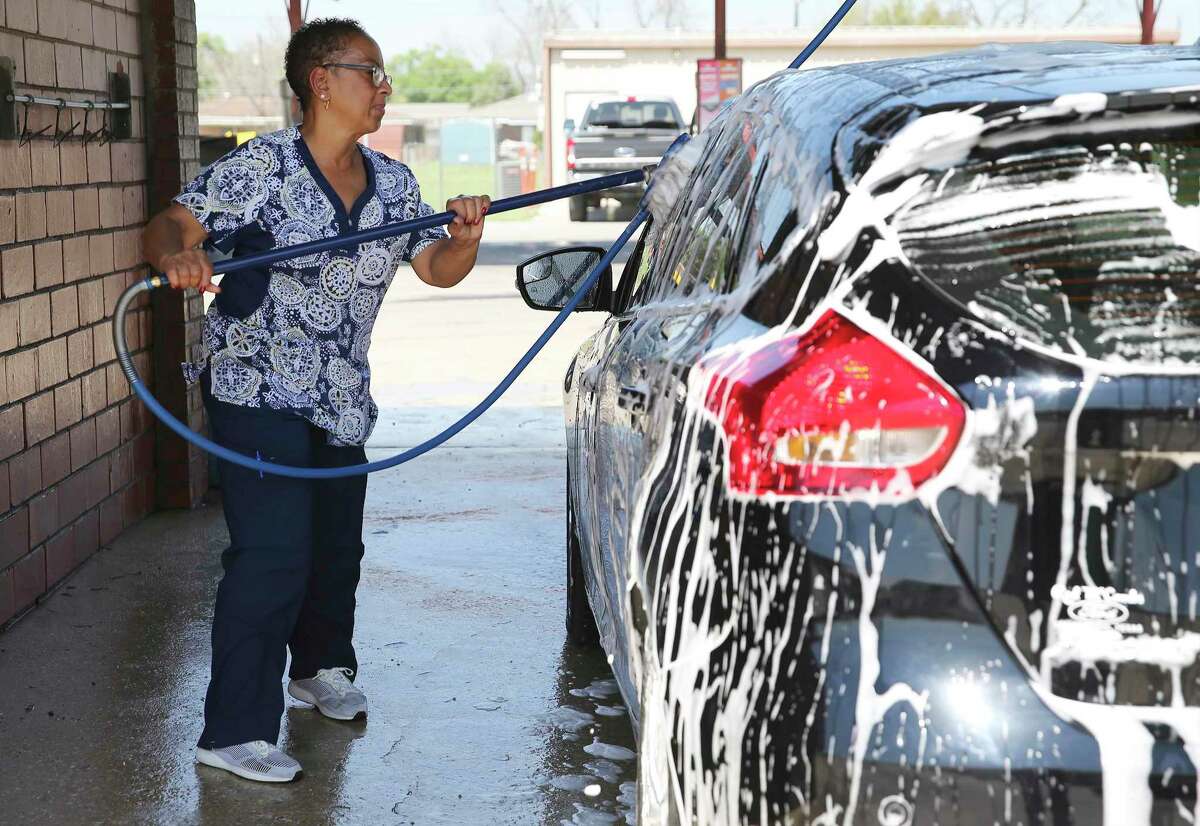 Diana Lambert, a certified nursing assistant, washes her vehicle at a car wash on Rigsby. City and county stay-at-home orders aim to shut down businesses — initially through April 9 — that aren’t essential to San Antonians’ day-to-day survival. Grocery stores, gas stations, financial institutions, health care facilities and pharmacies are no-brainers — clearly essential. But things get confusing after that.