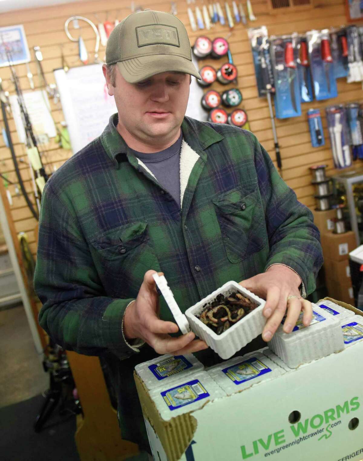 Store owner William Ingraham shows nightcrawler fishing bait available at The Sportsman’s Den in the Cos Cob section of Greenwich, Conn. Wednesday, March 25, 2020. Connecticut Gov. Ned Lamont declared Wednesday the start of the fishing season as a measure to prevent the spread of the coronavirus by eliminating large crowds that typically accompany opening day. "On a nice day, what better place is there to socially distance yourself than out on the water?" said Ingraham.