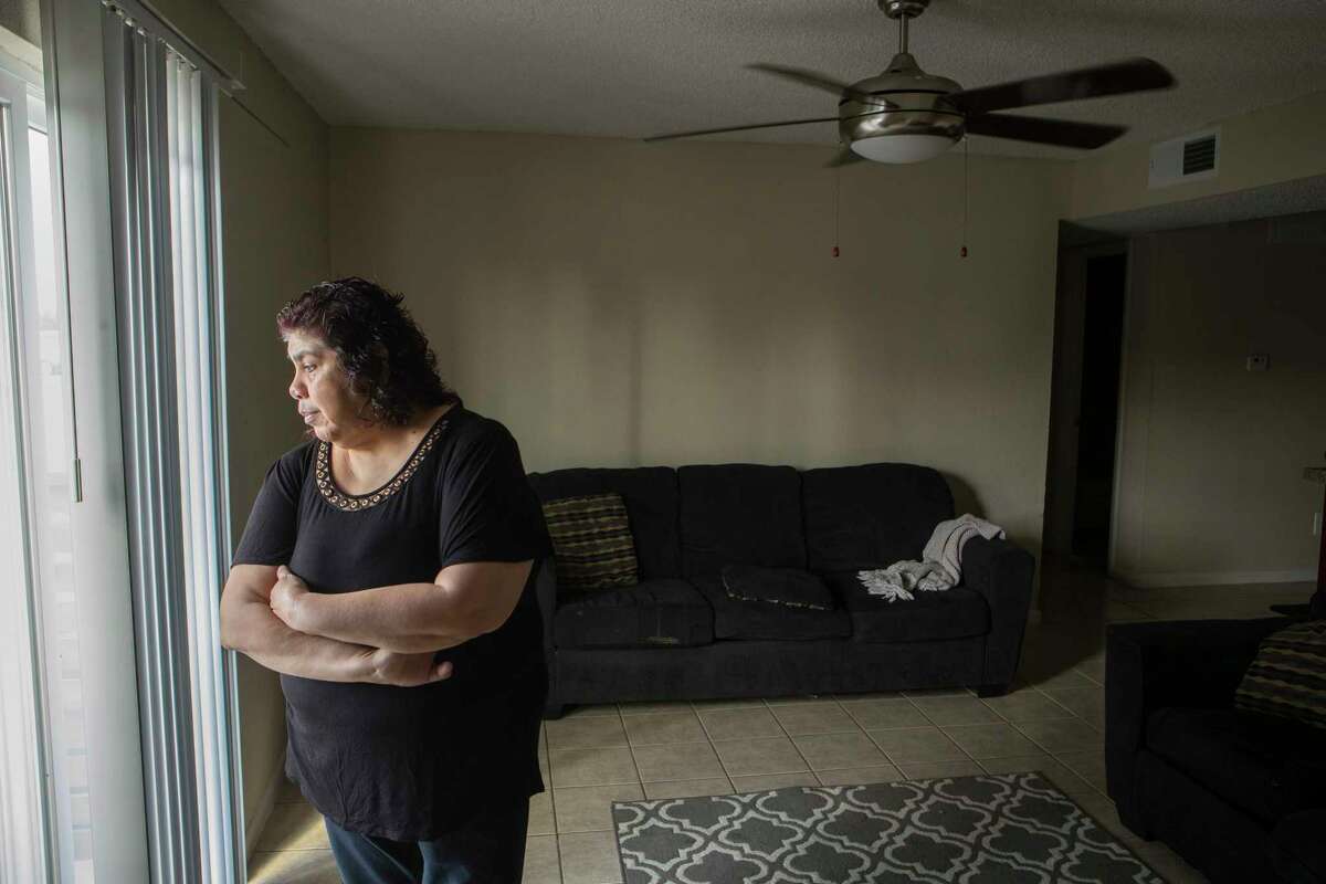 Anna Alvarez, who is a wheelchair attendant at George Bush Intercontinental Airport, stands in her apartment on Thursday, March 26, 2020 in Houston. She and two of her daughters, who all work at IAH, and have now seen their weekly paychecks slashed by at least 85 percent. Soon, she expects all three of them will be out of work since several of the major airlines have announced severe cutbacks beginning April 1.