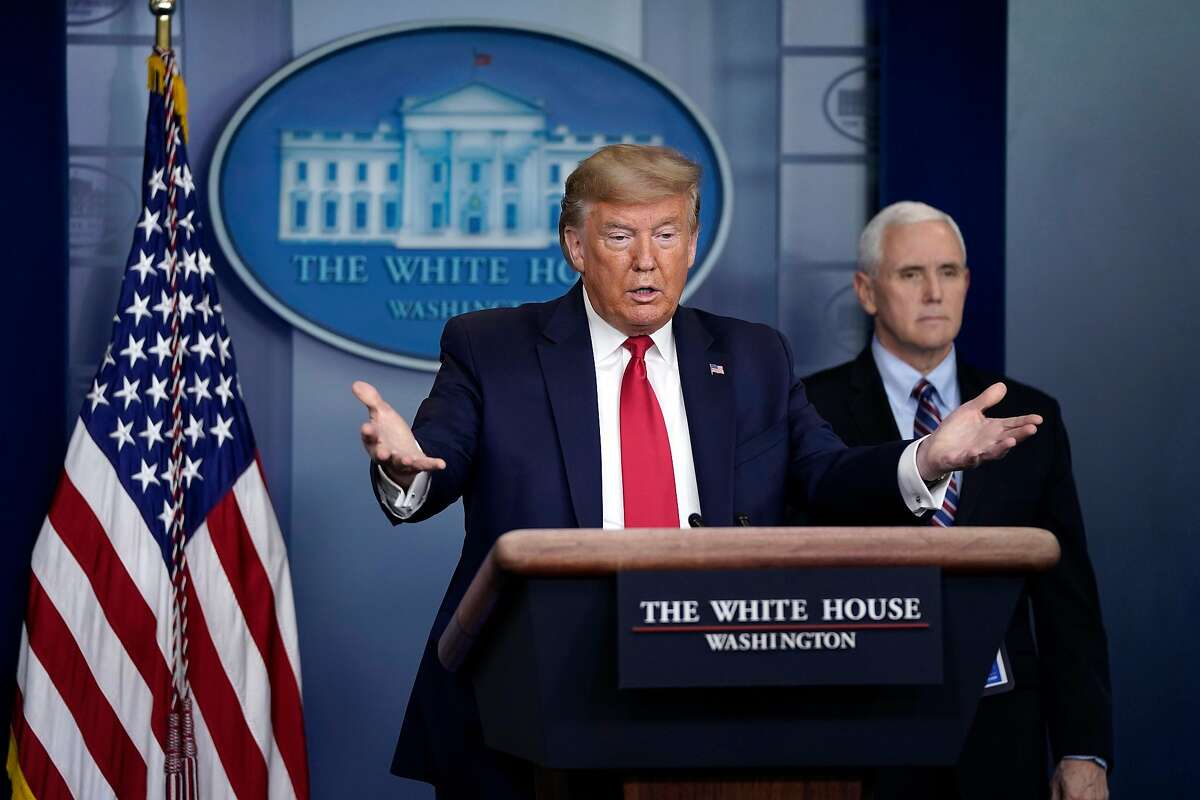 WASHINGTON, DC - MARCH 26: U.S. President Donald Trump gestures as Vice President Mike Pence looks on during a briefing on the coronavirus pandemic in the press briefing room of the White House on March 26, 2020 in Washington, DC. The U.S. House of Representatives is scheduled to vote Friday on the $2 trillion stimulus package to combat the effects of the COVID-19 pandemic. (Photo by Drew Angerer/Getty Images) *** BESTPIX ***