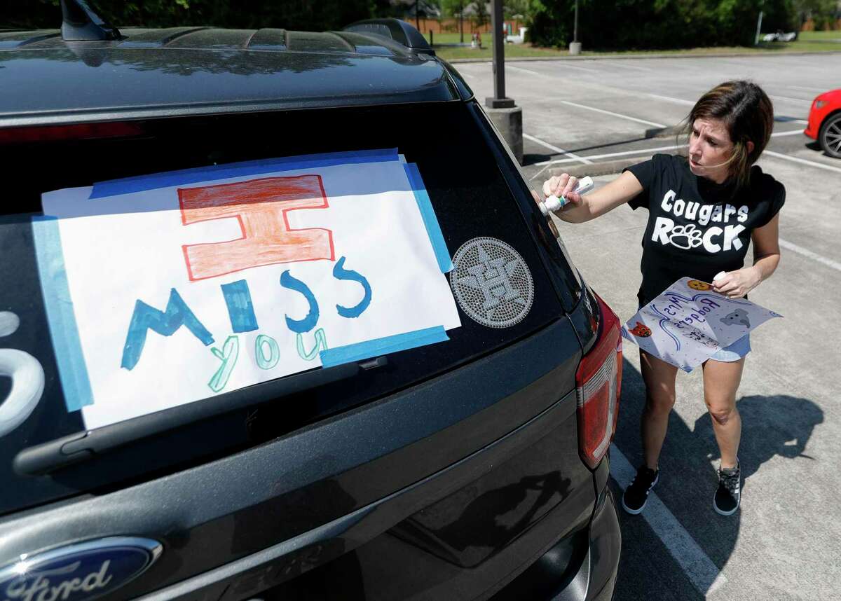 Kindergarten teacher Jamie Rodgers decorates her car as teachers with Kaufman Elementary School take part in a parade through nearby neighborhoods, Wednesday, March 25, 2020, in Spring.