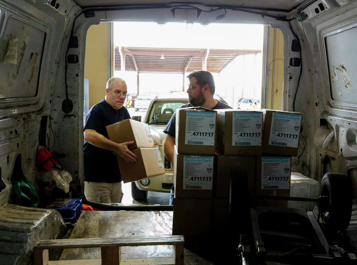 SETRAC Emergency Operations' Donald Morrison, left, and Austen McMillin load up medical supplies into a van from Memorial Hermann Hospital at the Strategic National Stockpile distribution site Wednesday, March 18, 2020, in Houston.
