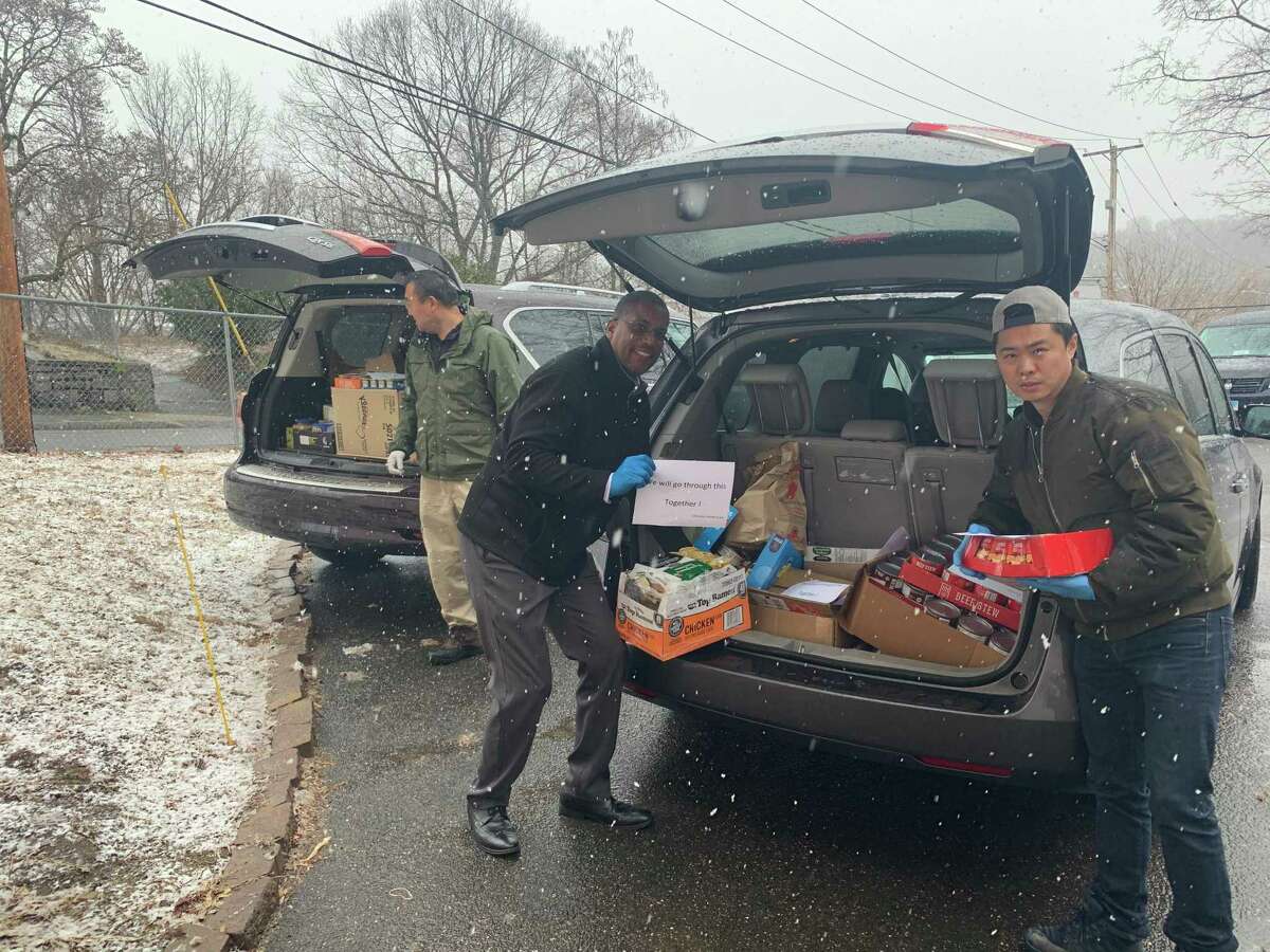 State Sen. George Logan, R-Ansonia, center, joins Jason Zhao and Han Chen, of Orange, left, in unloading two of the SUVs that delivered thousands of cans and pacakages of food to the Salvation Army Food Bank in Ansonia Monday. The food was a donation from the region’s Chinese-American community.