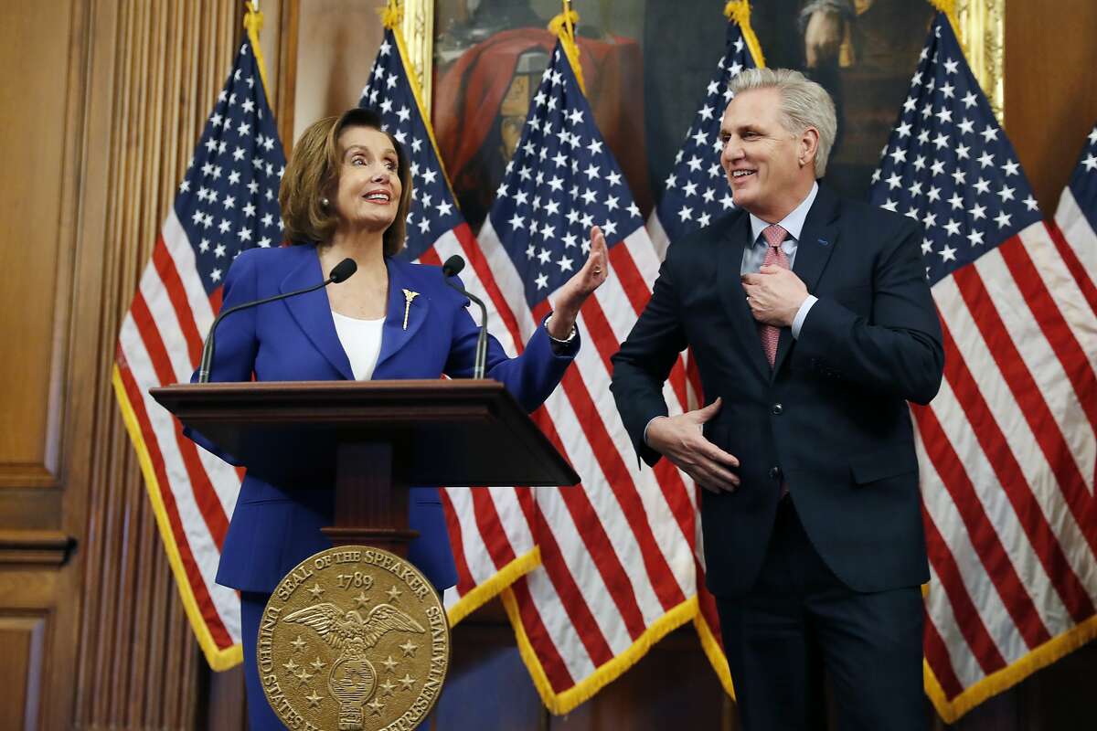 House Speaker Nancy Pelosi of Calif., accompanied by House Minority Leader Kevin McCarthy of Calif., participates in a bill enrollment ceremony for the Coronavirus Aid, Relief, and Economic Security (CARES) Act, after it passed in the House, on Capitol Hill, Friday, March 27, 2020 in Washington. The $2.2 trillion package will head to Trump's desk for his signature. (AP Photo/Andrew Harnik)