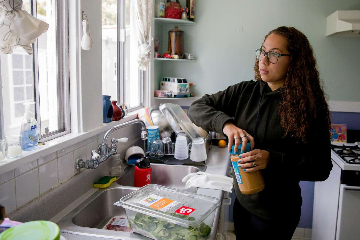 Anissa Perez, 18, makes a peanut butter and banana smoothie during a study break at home in Oakland, Calif. Thursday, March 26, 2020. Anissa, a freshman at University of Miami, is now living and studying from her parent's home where she shares a room with her 15-year-old sister. Schools across the country have closed due to the outbreak of the Coronavirus.