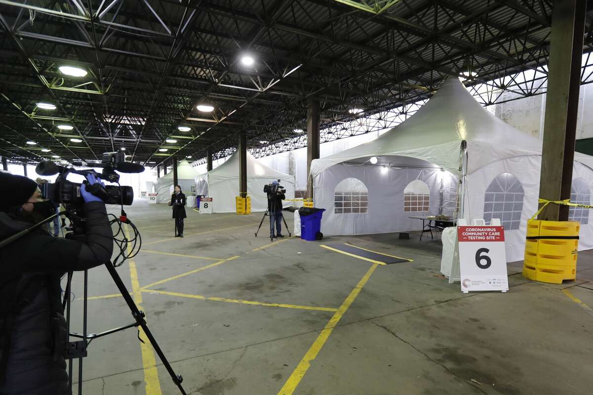 Journalists photograph the examination tents at the Michigan State Fairgrounds, Friday, March 27, 2020, in Detroit, where the city is preparing for coronavirus drive up testing. (AP Photo/Carlos Osorio)