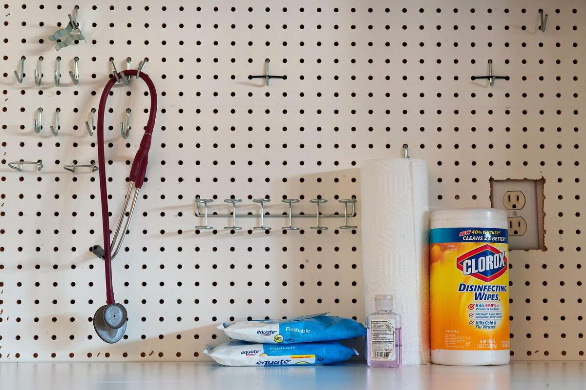 After wiping down her stethoscope, Mawata Kamara hangs it on a pegboard in her garage on Friday, March 27, 2020, in Tracy, Calif.