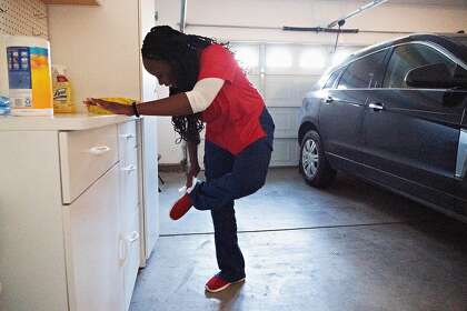 Mawata Kamara wipes down her nurse�s shoes before removing them in her decontamination area in her garage on Friday, March 27, 2020, in Tracy, Calif.