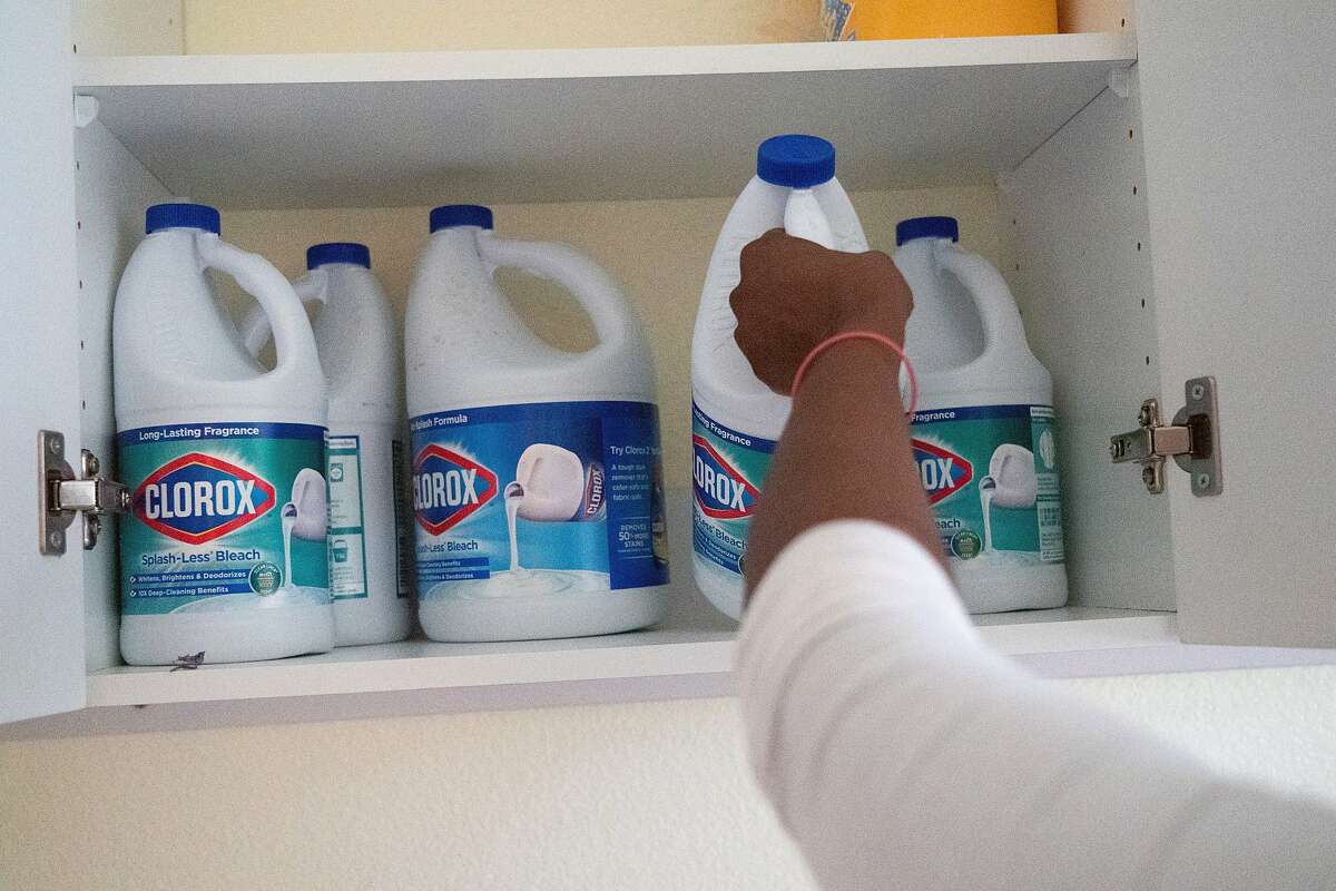 Mawata Kamara pulls a bottle of chlorine in her laundry room on Friday, March 27, 2020, in Tracy, Calif.