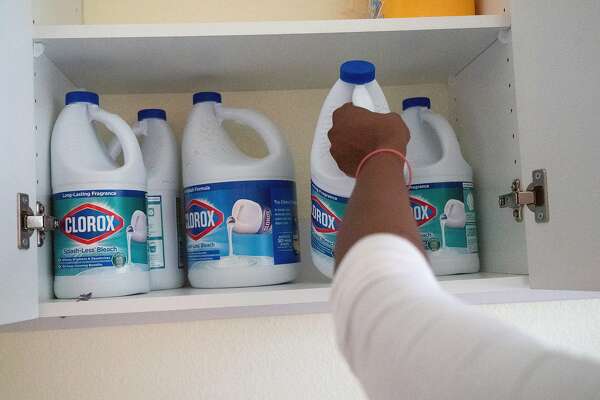 Mawata Kamara  pulls a bottle of chlorine in her laundry room on Friday, March 27, 2020, in Tracy, Calif.