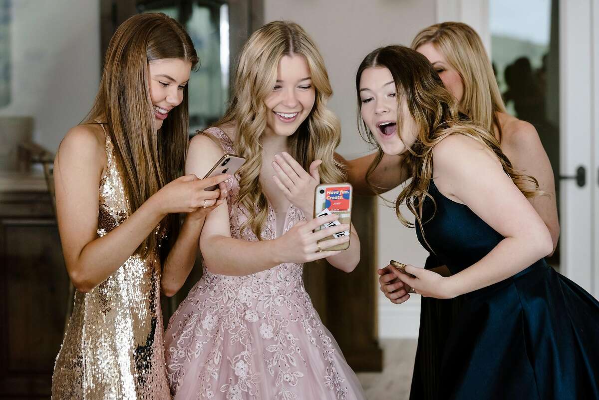 From left Allison Reese, Natalie Reese, Brooke Reese, and their mother Laurie Reese, watch TikTok videos of themselves celebrating the girls' canceled prom from their home in Danville, Calif, on Saturday, March 28, 2020.