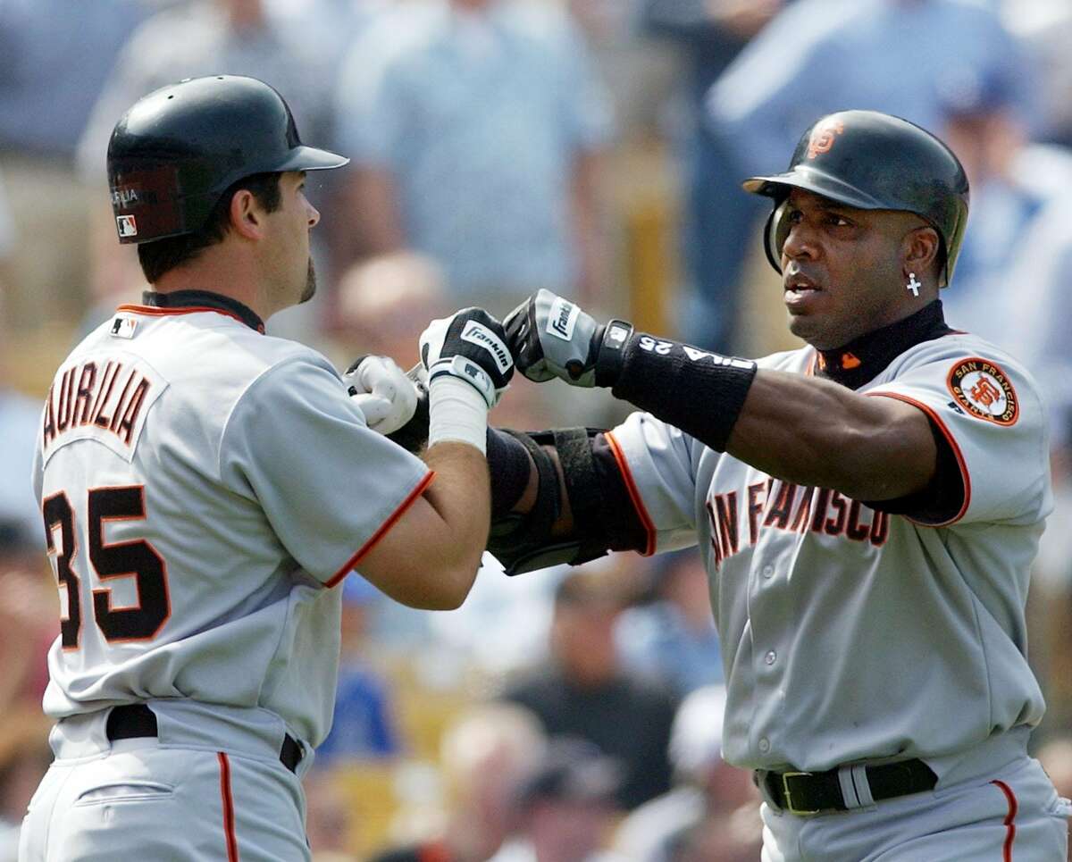 San Francisco Giants home run king Barry Bonds, right, is congratulated by teammate Rich Aurilia after hitting a three-run home run off Los Angeles Dodgers pitcher Kevin Brown for his first home run of the season during the second inning of their season opener at Dodger Stadium, Tuesday, April 2, 2002, in Los Angeles. Aurilia scored on the home run. (AP Photo/Kevork Djansezian)
