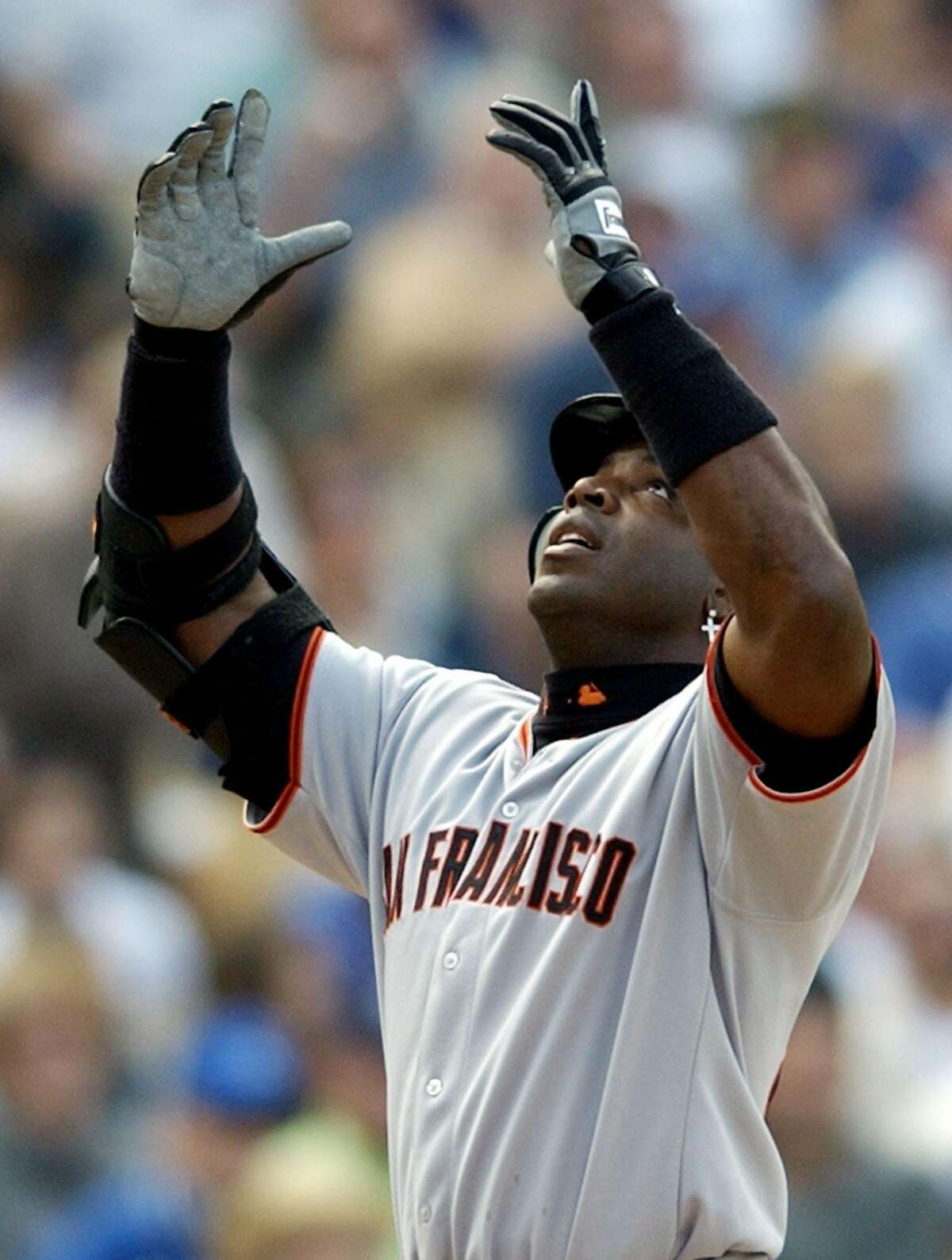 San Francisco Giants slugger Barry Bonds raises his arms as he crosses home plate after hitting his second home run of the game against the Los Angeles Dodgers pitcher Omar Daal during the seventh inning of the season opener at Dodger Stadium Tuesday, April 2, 2002, in Los Angeles (AP Photo/Kevork Djansezian)