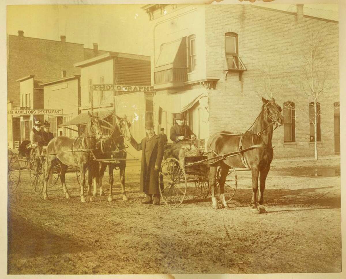 E.C. Berryman standing in front of his photography studio located on the corner of Main and Townsend. c.1886 (Midland County Historical Society)