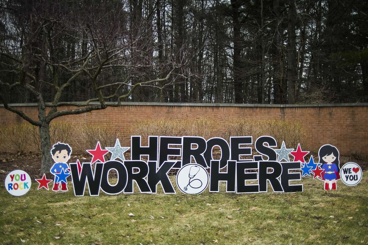 A sign installed by Morgan Jackson, owner of Sign Gypsies Mid Michigan, honors hospital workers at the Saginaw Road entrance for MidMichigan Medical Center - Midland Monday, March 30, 2020. Jackson donated the sign, which reads "Heroes work here," to thank hospital staff for their hard work and long hours during the coronavirus pandemic. (Katy Kildee/kkildee@mdn.net)