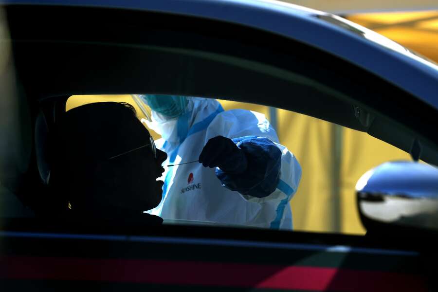 A medical professional administers a coronavirus (COVID-19) test during a drive-thru testing station on March 26, 2020 in Daly City, California. New coronavirus testing stations are opening up each day in the San Francisco Bay Area.