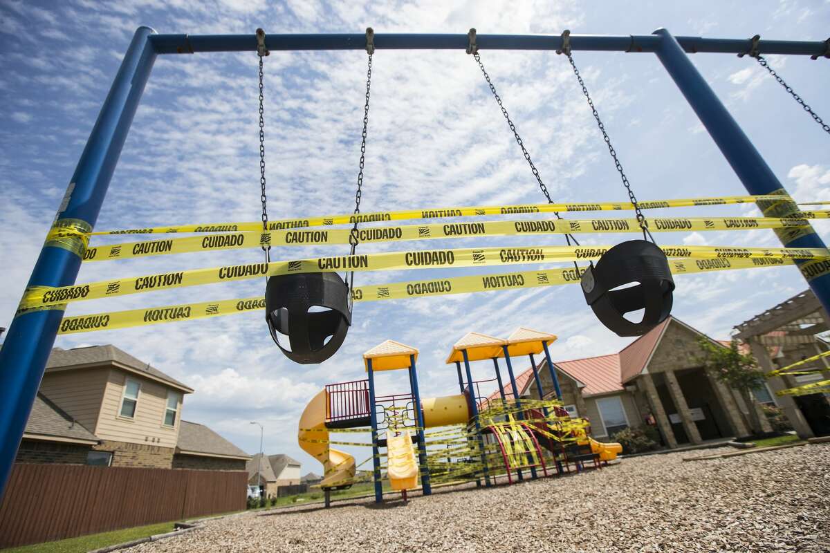 A playground is covered on caution tape, to discourage people from playing there due to coronavirus, in the Legends Trace subdivision on Sunday, March 29, 2020 in Spring.