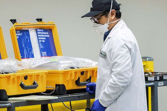 FILE - In this Saturday, March 28, 2020, file photo, staff work in a ventilator refurbishing assembly line at Bloom Energy campus in Sunnyvale, Calif. Bloom Energy is a fuel cell generator company that has switched over to refurbishing ventilators as an increasing number of patients experience respiratory issues as a result of COVID-19, caused by the new coronavirus. With cases of coronavirus surging and the death toll surpassing 100, lawmakers are pleading with cooped-up Californians to spend a second weekend at home to slow the spread of infection. California could see conditions similar to New York "if we stop practicing physical distancing ... if we pull back from our stay-at-home policy ... if we go back to our normal routines without bending the curve," Newsom said while touring a Silicon Valley firm that is refurbishing outdated ventilators for hospitals. (Beth LaBerge/KQED via AP, Pool)