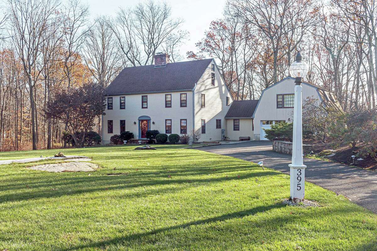 The beige colonial house at 395 Thayer Pond Road in South Wilton sits on a level corner lot of two acres.