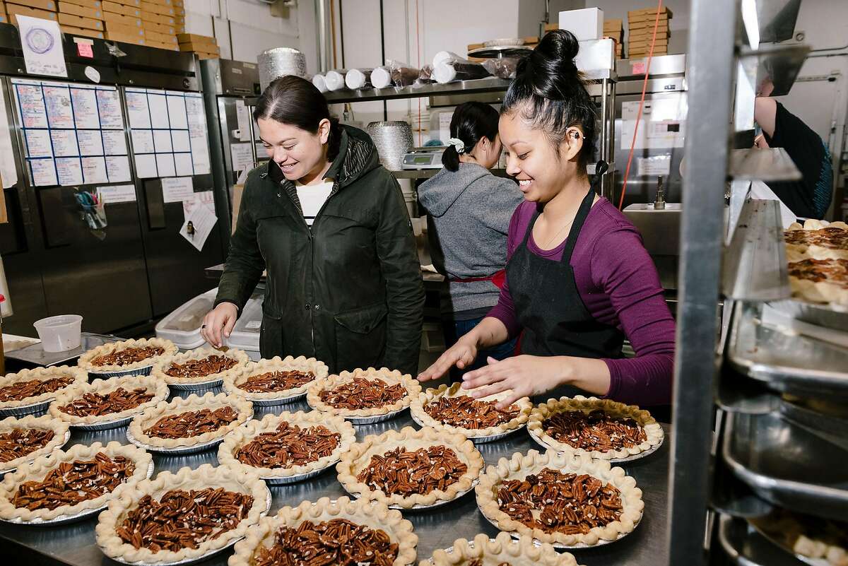 Owner Lenore Estrada, left, checks in on Bourbon Pecan pies being made by Julie Tran at Three Babes Bakeshop in San Francisco, California, on Friday, March 6, 2020. Three Babes Bakeshop, which largely caters to local San Francisco tech employers, is seeing a dramatic decrease in business since tech companies are having employees work from home due to fears over the Coronavirus, and is having to make cutbacks in their production numbers and potentially may have to cut some workers' hours.