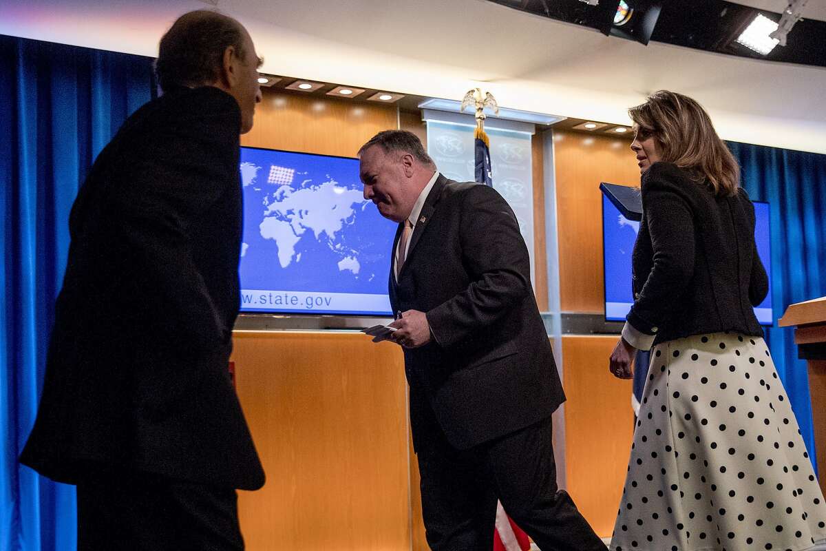 Special Representative for Venezuela Elliott Abrams, left, takes the podium as Secretary of State Mike Pompeo, accompanied by State Department spokeswoman Morgan Ortagus, right, departs after speaking at a news conference, Tuesday, March 31, 2020, in Washington. (AP Photo/Andrew Harnik, Pool)