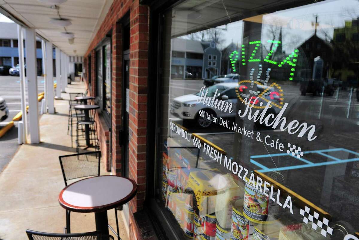 Italian Kitchen is open for business at Heritage Square in Fairfield, Conn., on Wednesday Mar. 18, 2020. Other businesses notify customers of their status with notes in their windows due to the coronavirus. Many have closed alltogether or are serving customers by appointment only.