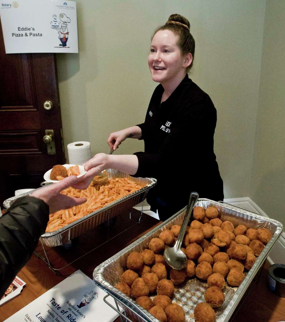 Christa Lowenstein, of Eddie's Pizza & Pasta, serves food during last year's annual Taste of Ridgefield at the Lounsbury House.