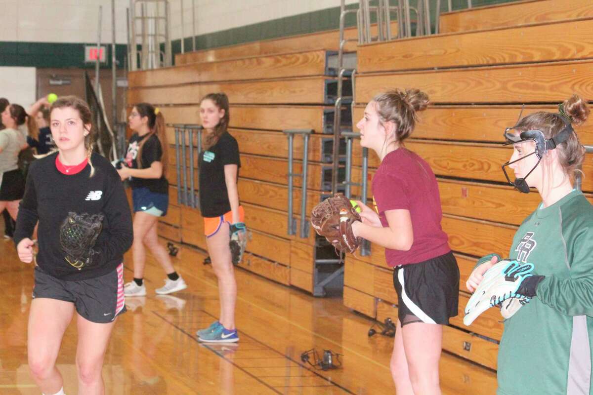Cayla Trowbridge (left) leads her team in a practice session prior to the suspension of spring sports on March 13. (Herald Review/John Raffel)