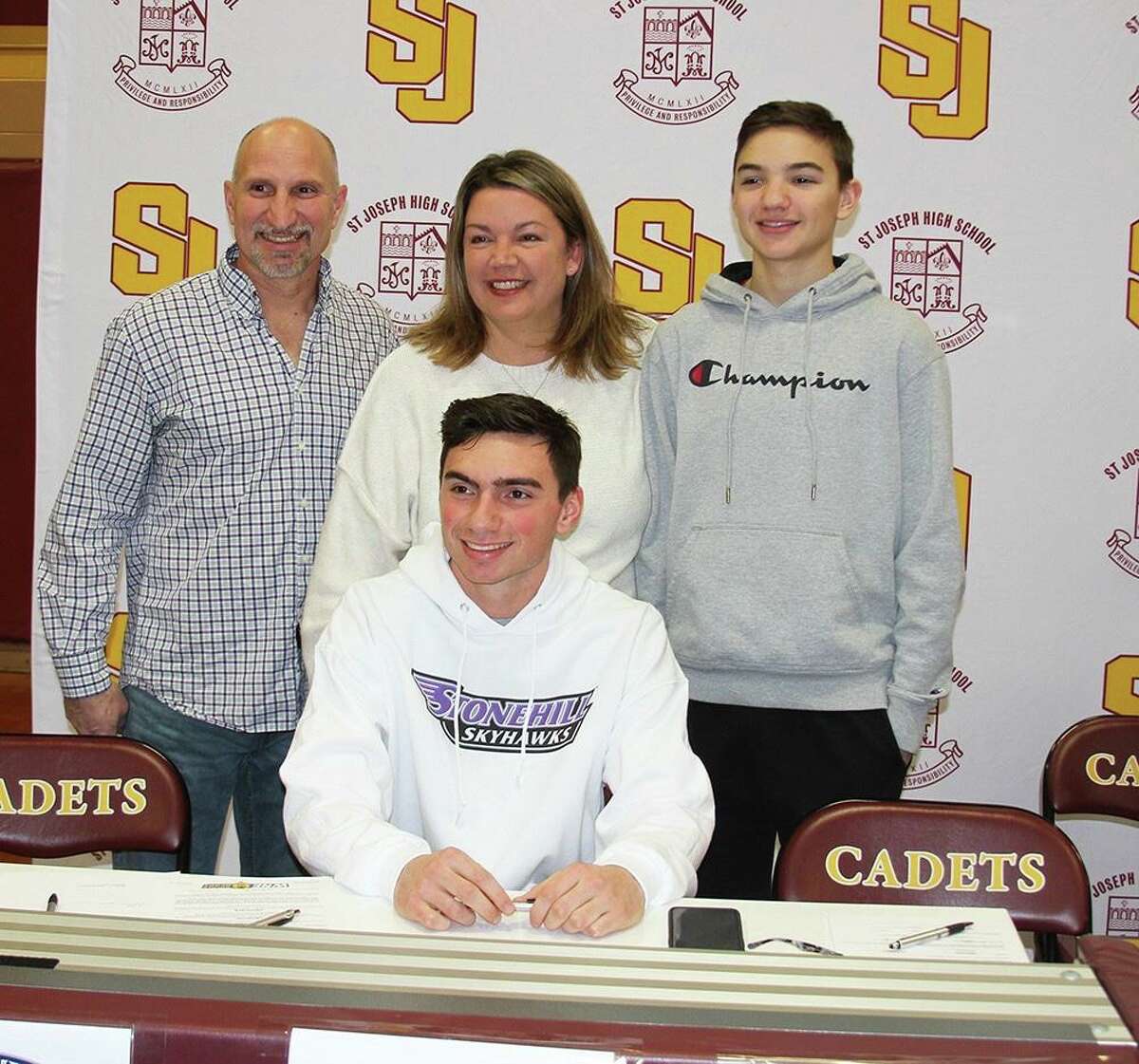 Will Diamantis is joined by dad George, mom Susan and brother Charlie when he signed his letter of intent to play football at Stonehill College in Easton, Mass.