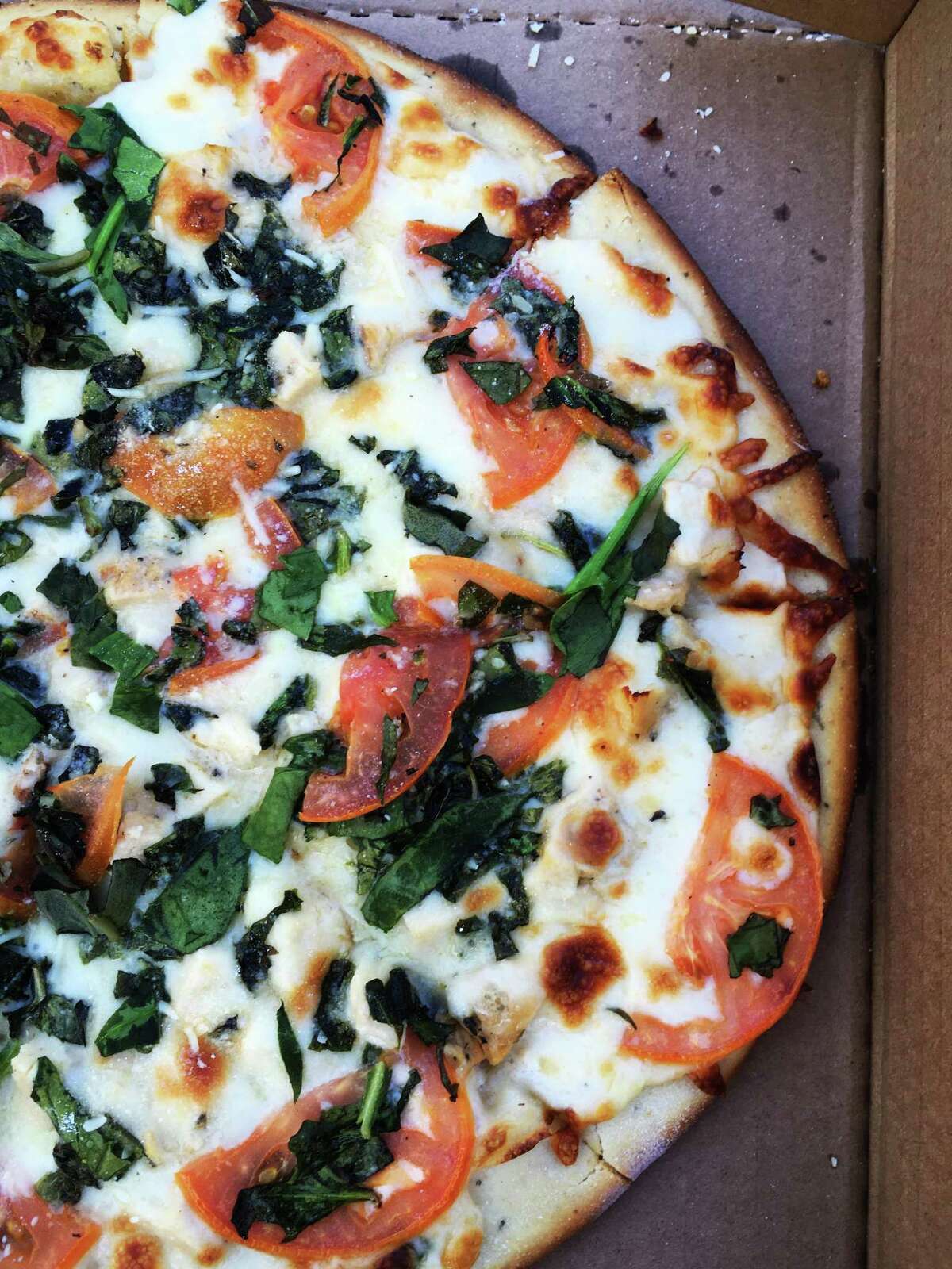 The chicken alfredo pizza with spinach is one of many specialty pizzas available at Hungry Chameleon Pizzeria.