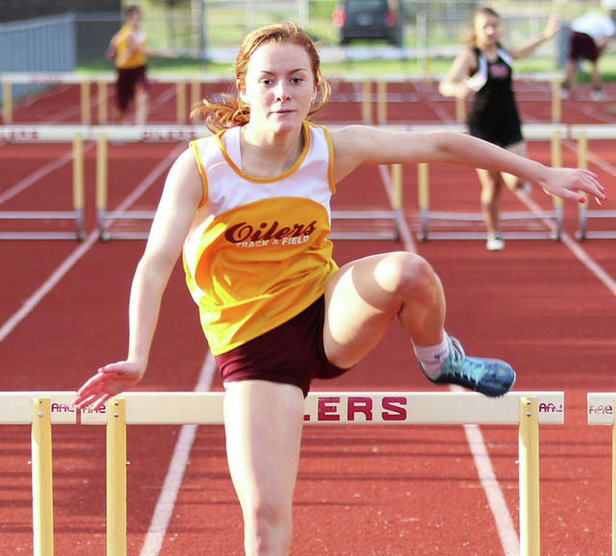 EA-WR’s LeighAnn Nottke clears the final hurdle on her way to a victory in the 300-meter hurdles at the Prairie State Conference meet last season in Wood River. Nottke, a senior, and other spring sports athletes retain hope for their season to begin sometime in May.