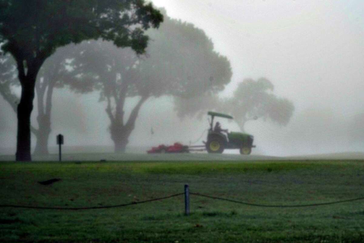 A groundskeeper is seen through the dense fog as he maintains the greens and fairways at Olmos Basin Golf Course on March 25. This week, the course was closed pending results of a COVID-19 test of an ill employee who cleans golf carts there.