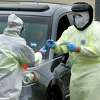 Workers with Murphy Medical Associates conduct corona virus at a drive-thru testing station Tuesday, March 31, 2020, at Bedford Middle School in Westport, Conn. Due to a large coronavirus outbreak in Westport, the Westport Weston Health District arranged for additional community testing. Residents of Westport and Weston were tested by Murphy Medical Associates, a private company, from 8:30 a.m. to noon.