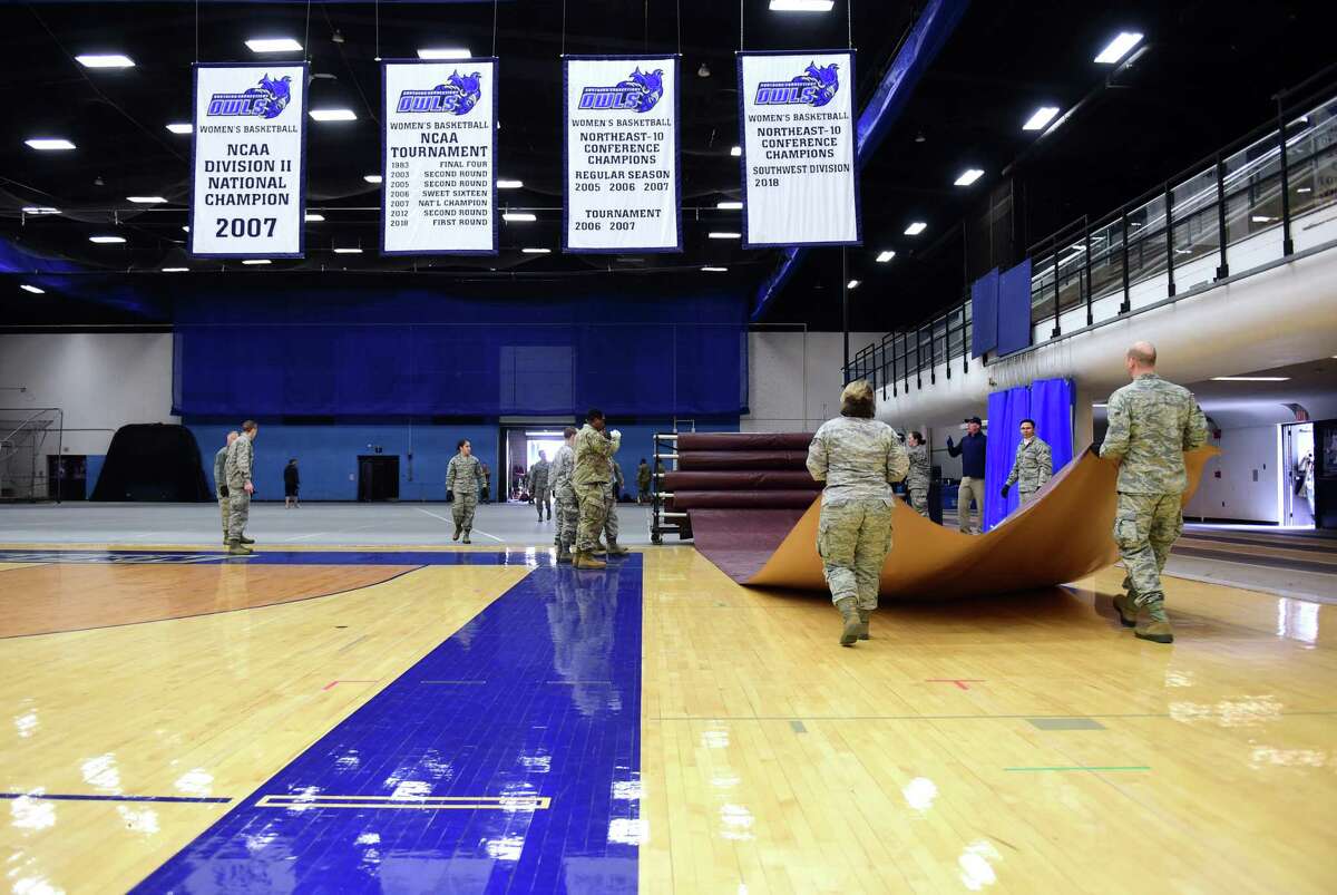 Members of the Connecticut National Guard cover the floor of Moore Field House at Southern Connecticut State University in New Haven with tarps in preparation for a 250-bed field hospital on March 31.