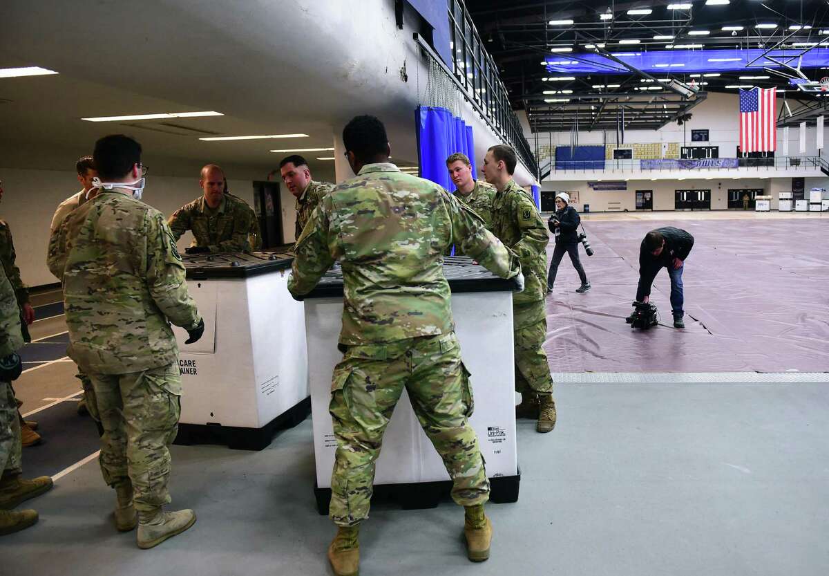 Members of the Connecticut National Guard move crates of supplies into place in Southern Connecticut State University's Moore Field House in New Haven in preparation for a 250-bed field hospital on March 31.