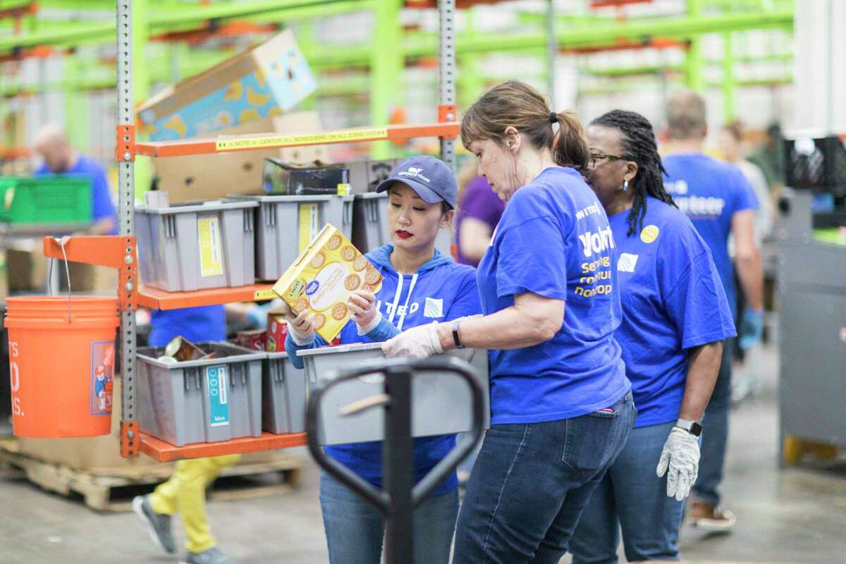 In this 2018 file photo, volunteers help package food at the Houston Food Bank. The nonprofit is partnering with Houston ISD to provide food to families during the novel coronavirus pandemic, which has caused unprecedented demand for support from the organization.