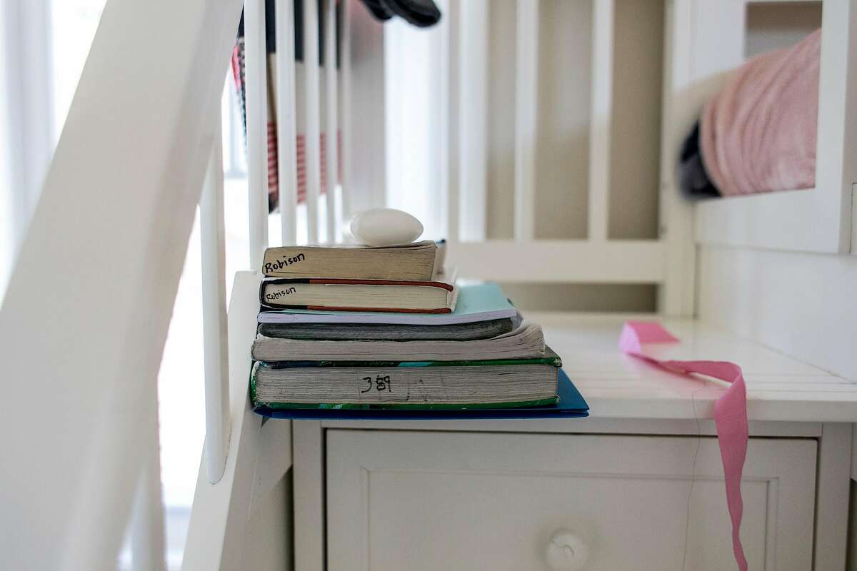 Nalani Sanchez's school books sit on the side of her bed at her home in Half Moon Bay, Calif. on Wednesday, April 1, 2020. Schools throughout the Bay Area have announced closures through the end of the school year.