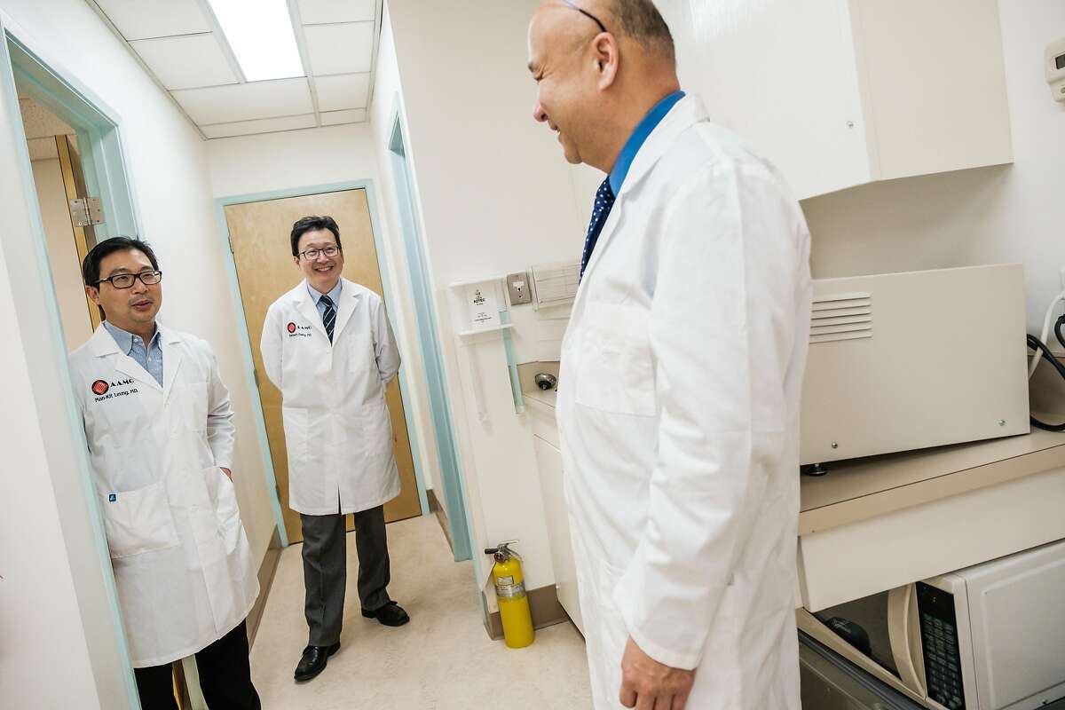 Dr. Man-Kit Leung, left, chats with Dr. Kenneth Chang, back, and Dr. Joseph Woo at Dr. Leung’s office in San Francisco, Calif. on Wednesday April 1, 2020.