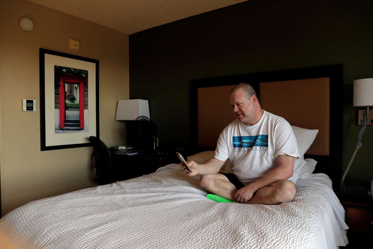 Chad Baker, RN, has a facetime chat with his husband in his hotel room where he has been living away from his husband in Richmond, Calif., on Tuesday, March 31, 2020. Baker, whose home is in San Leandro, is an ER nurse at Kaiser Richmond. He's been living in a hotel for a month because his husband has a compromised immune system and respiratory issues, so he can't risk exposing him. Kaiser won't pay for it (only medical prof's diagnosed with COVID-19 or ordered to quarantine get hotels paid for).