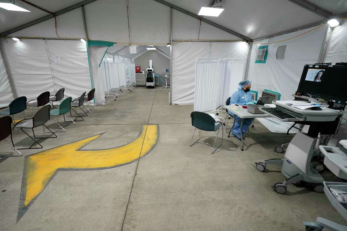 Dameka Larry, a patient access representative, works inside the Memorial Hermann Memorial City alternative care site tent for the care of potential COVID-19 patients Wednesday, April 1, 2020, in Houston. The hospital set up the tent inside the parking garage next to the emergency center.