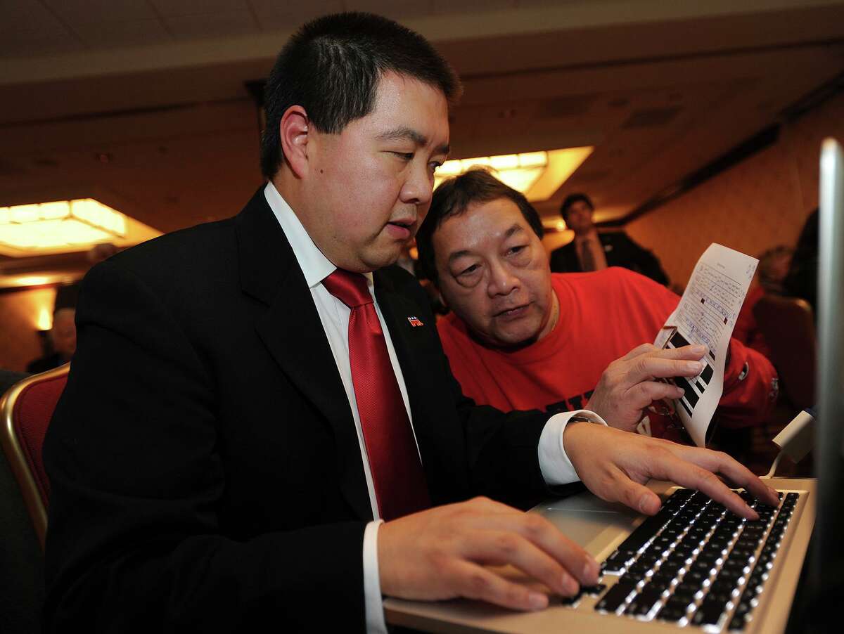 Bill Chin, left, and his father Ken Chin, both of Trumbull, post election results at the Trumbull Marriott in Trumbull, Conn. on Tuesday, November 4, 2014.