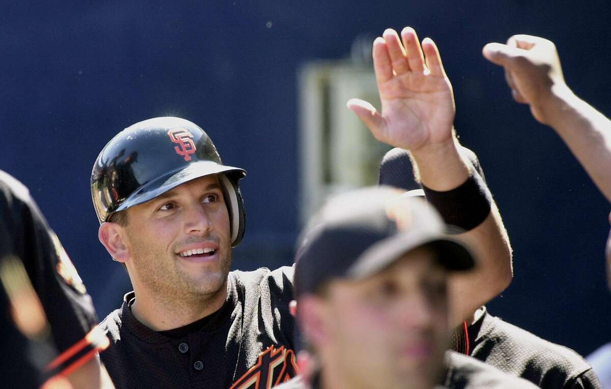 San Francisco Giants' Doug Mirabelli gets congratulations from teammates after returning to the dugout in the second inning against the San Diego Padres, Wednesday, March 14, 2001, during an exhibition game in Peoria, Ariz. Mirabelli drove in two runs on a triple and scored on Livan Hernandez's single. (AP Photo/Elaine Thompson)