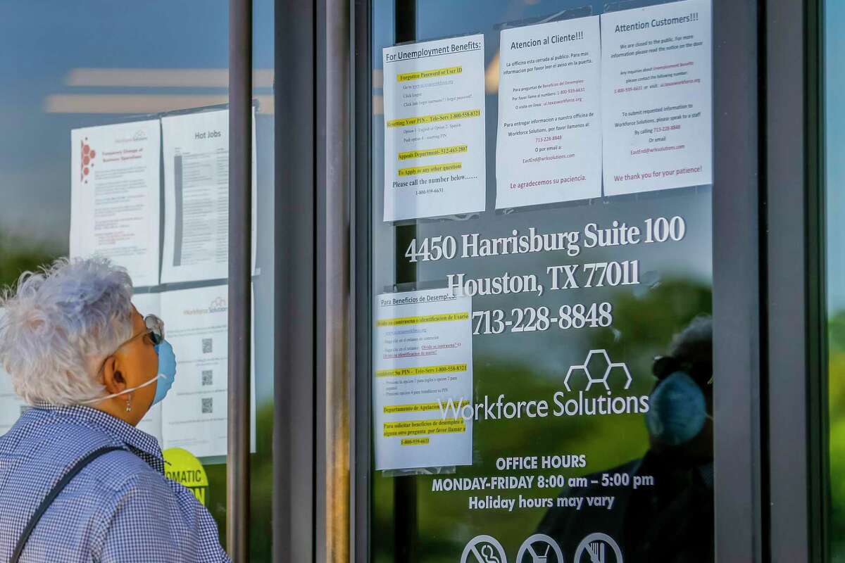 A woman looks at the signs saying that the Workforce Solutions office is closed due to the Covid-19 outbreak in April. The pandemic drove the worst job losses on record in Texas.