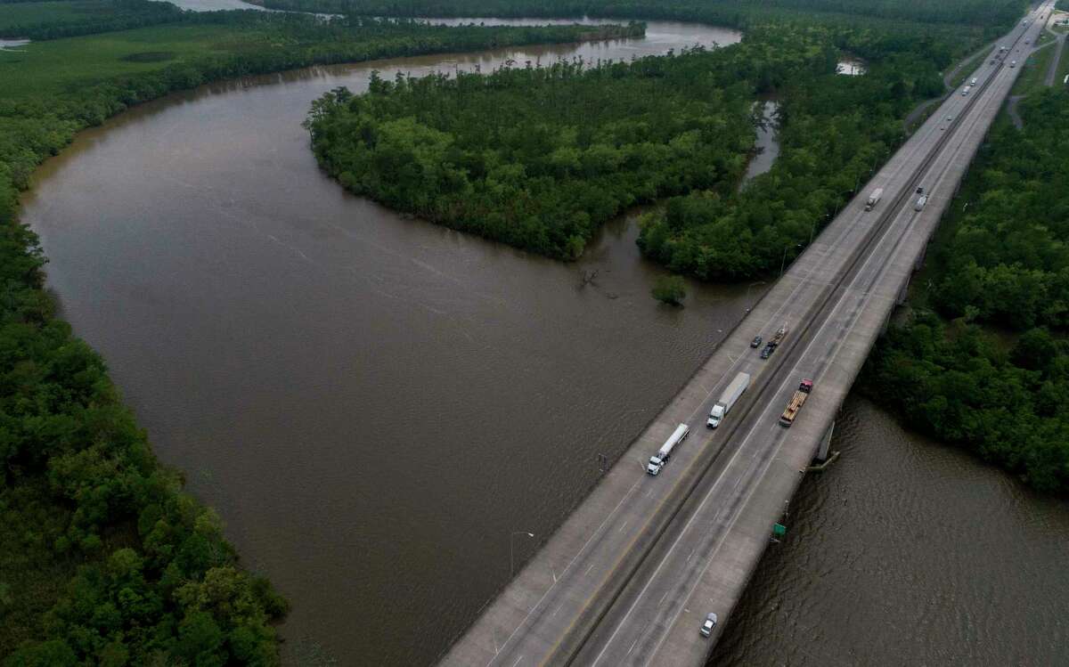 Motorists make their way east and west on Interstate 10 Highway at the Sabine River, which divides Texas and Louisiana. Less traffic means less gasoline and more trouble for the oil industry.