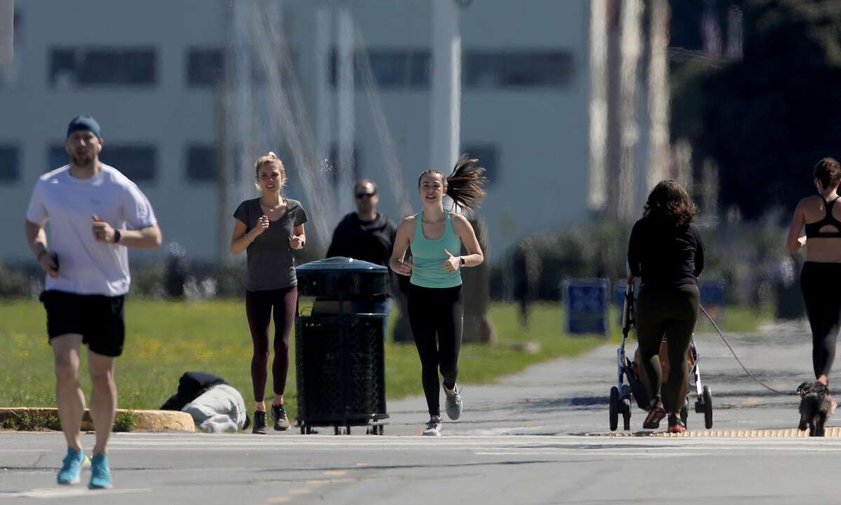 Isabel Glen (middle, green tank)) takes her sister Charlotte Glen (middle left) running at Fort Mason during lunchtime on Thursday, April 2, 2020, in San Francisco, Calif.