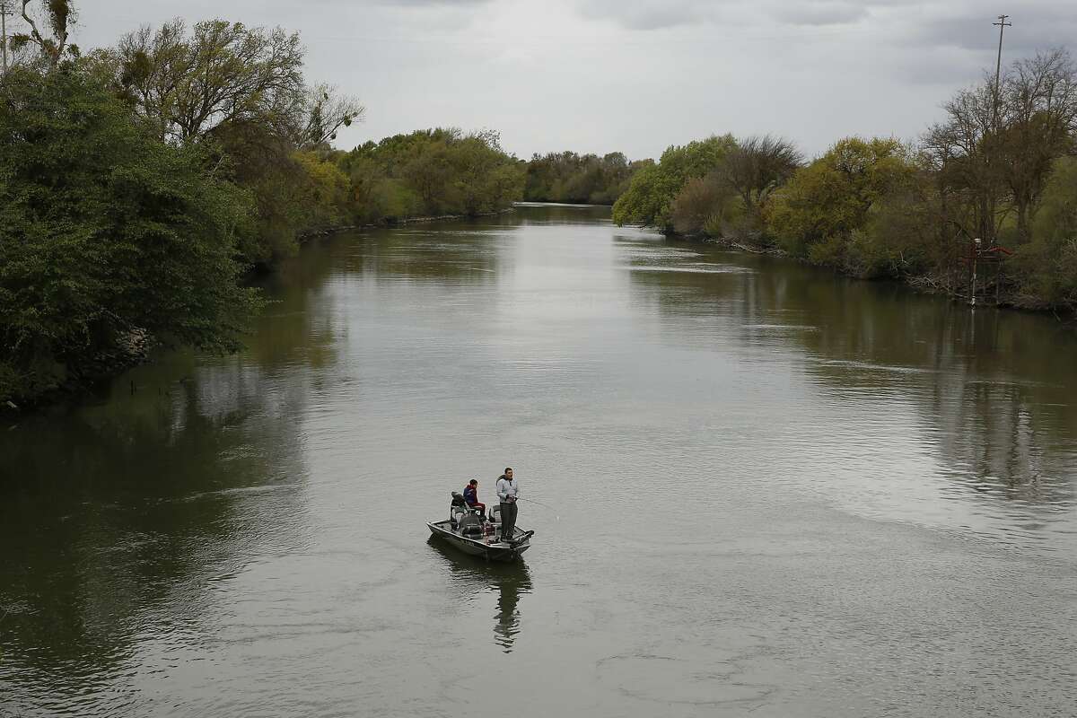 In this photo taken Tuesday, March 24, 2020, people fish in the Sacramento-San Joaquin River Delta's Elk Slough near Courtland, Calif. California regulators on Tuesday, March 31, 2020, announced a set of new rules on how much water can be taken from the state's largest rivers that run through the delta. The new rules have angered water agencies for limiting how much they can take. But the rules have also angered environmental groups, who say the limits are not low enough to protect endangered species. (AP Photo/Rich Pedroncelli)